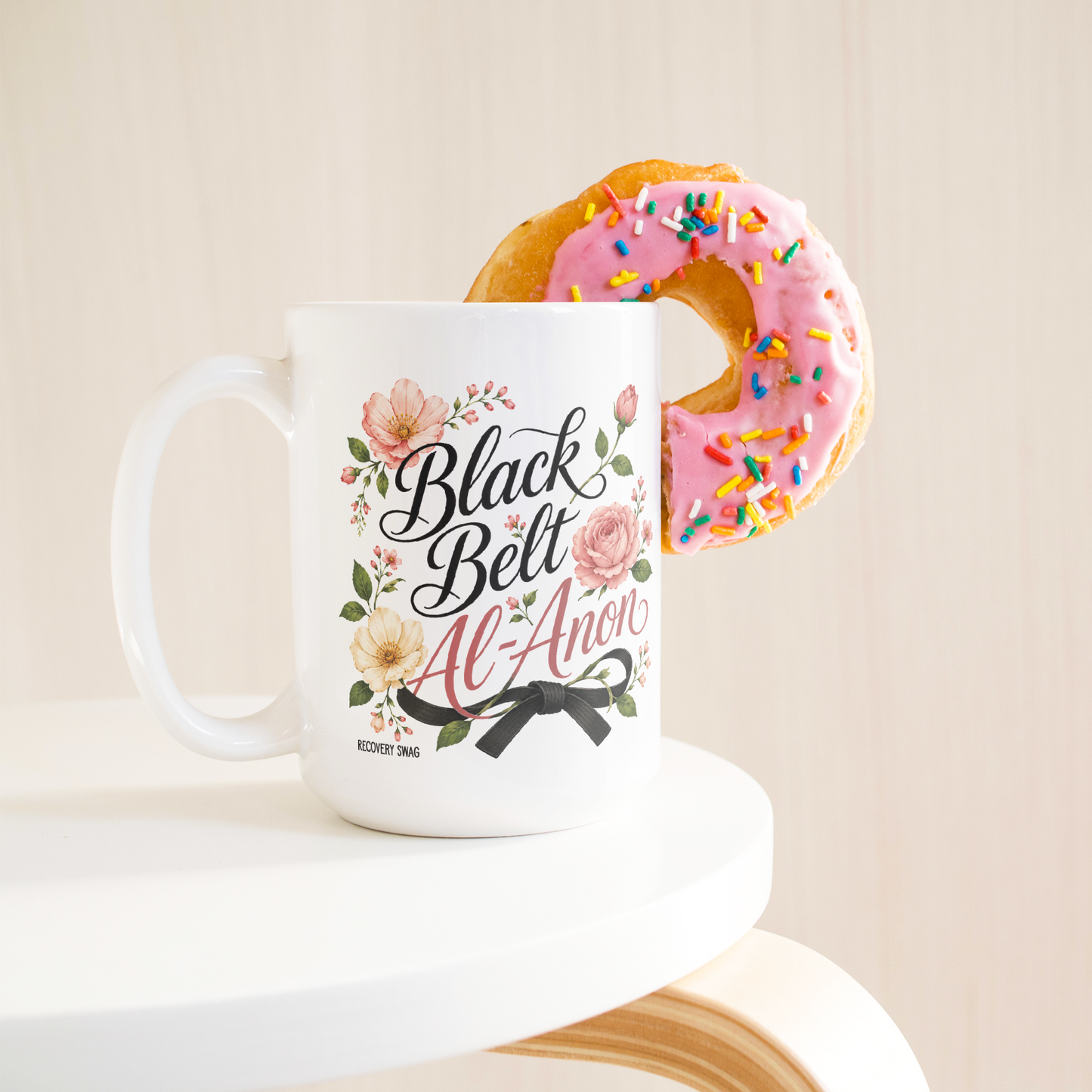 Black_Belt_Al-Anon_Recovery_Coffee_Mug__15ozWhiteMugLifetsyleDonutLH_Mockup.png_15824891